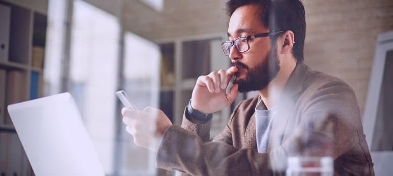 Imagem de um homem olhando no celular o Curso de Gestão de provedores