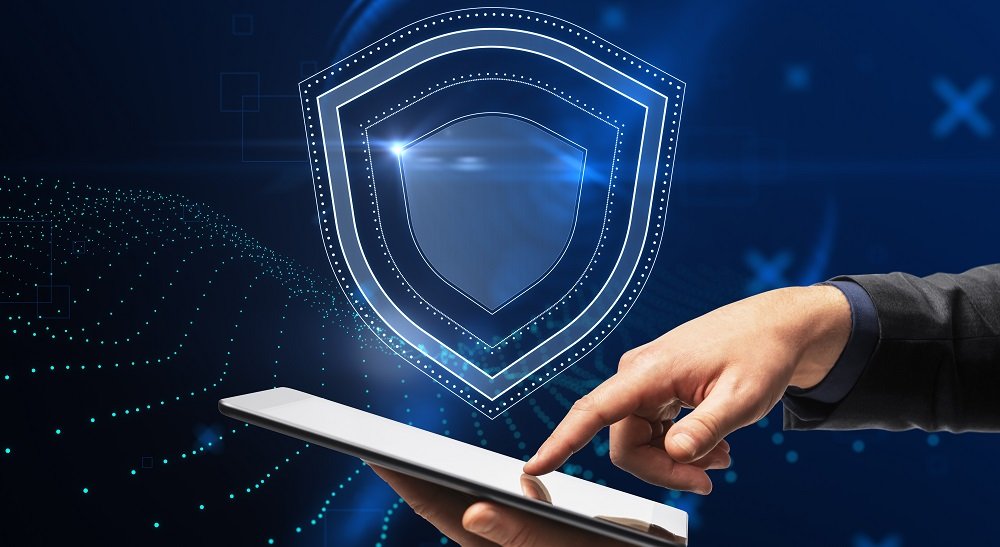 Mão do empresário apontando para o smartphone com holograma de escudo brilhante criativo simbolizando a proteção de dados
