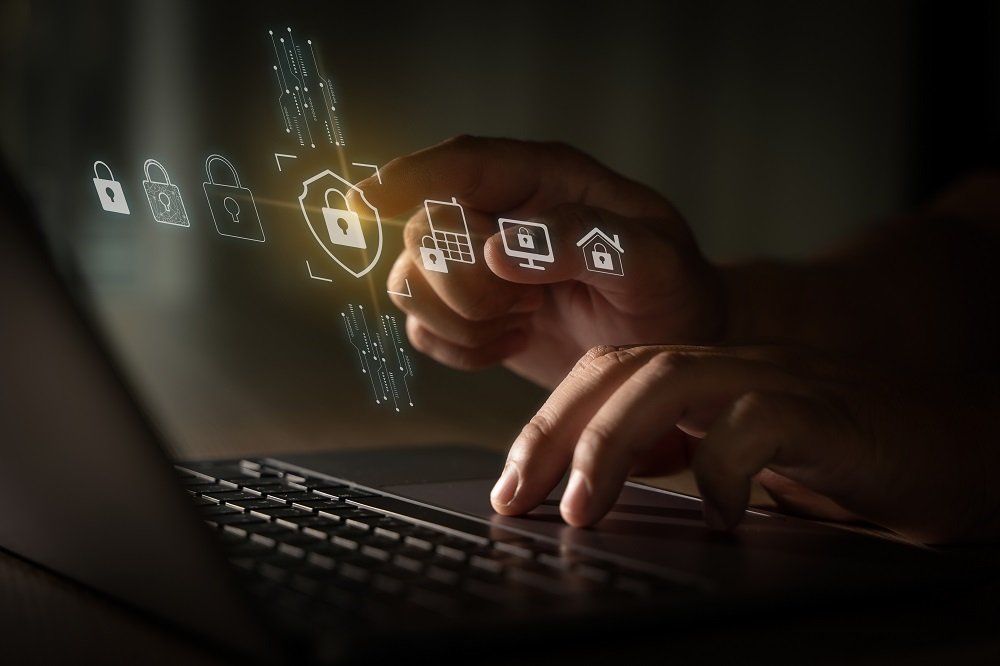Imagem das Mãos de um homem digitando em seu notebook e trabalhando para melhorar a cibersegurança do seu provedor