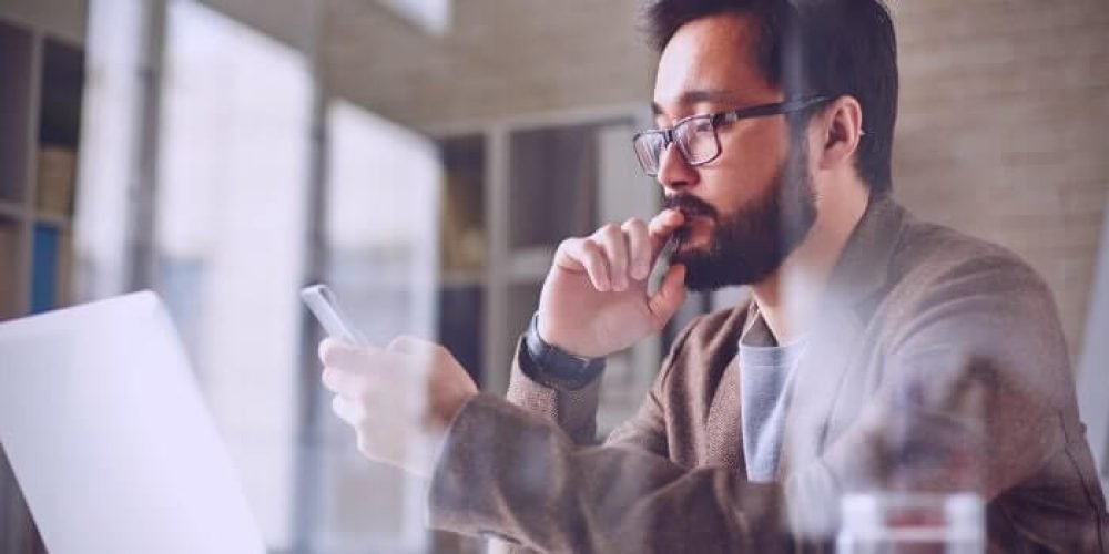 Imagem de um homem olhando no celular o Curso de Gestão de provedores