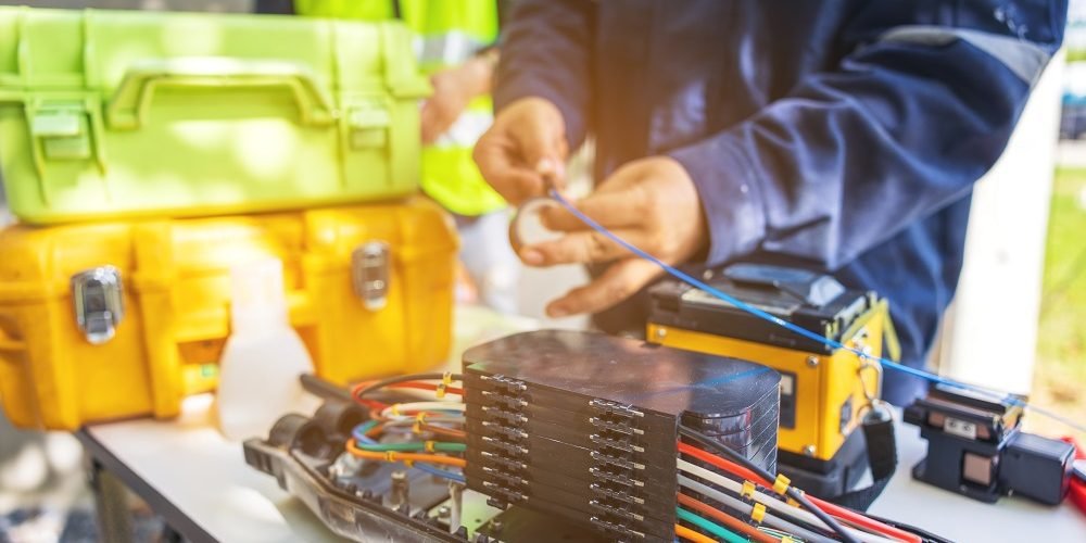 Engenheiro de ISP usando máquina de fusão de fibra óptica.