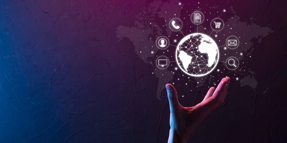 mão de uma pessoa segurando digitalmente o planeta terra com vários ícones ao redor, se conectando um com o outro