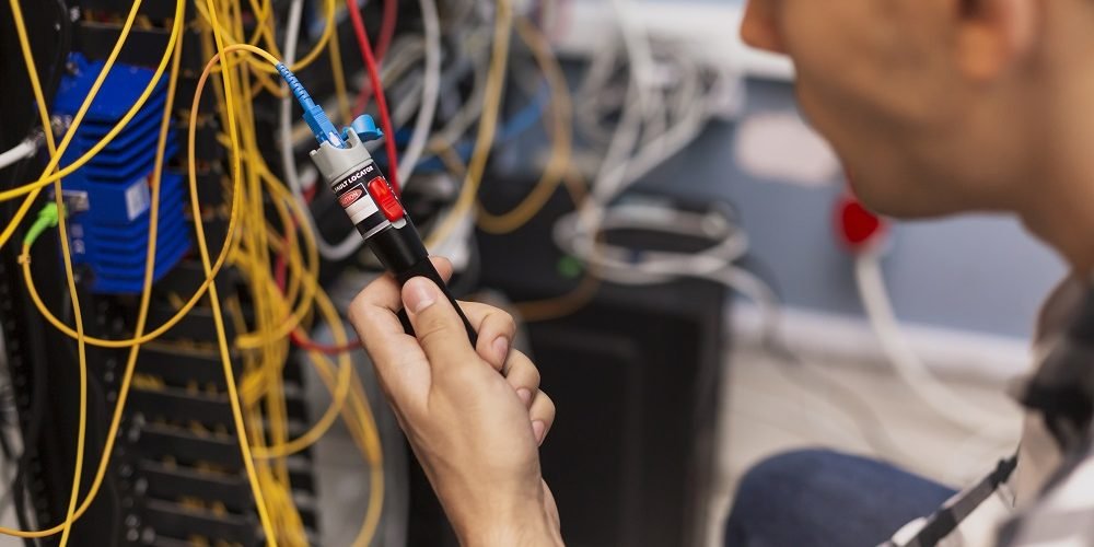 Engenheiro verificando se há rompimento de fibra óptica.